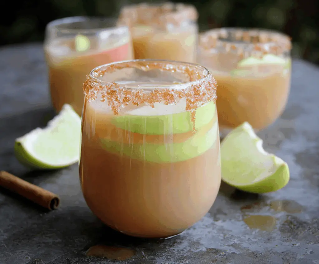 Refreshing Caramel Apple Mocktail in a clear glass garnished with apple slices and caramel drizzle, perfect for festive occasions