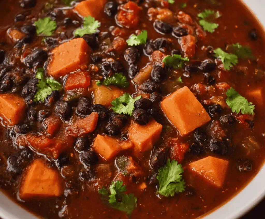Hearty sweet potato and black bean chili served in a bowl with fresh toppings, perfect for a cozy meal