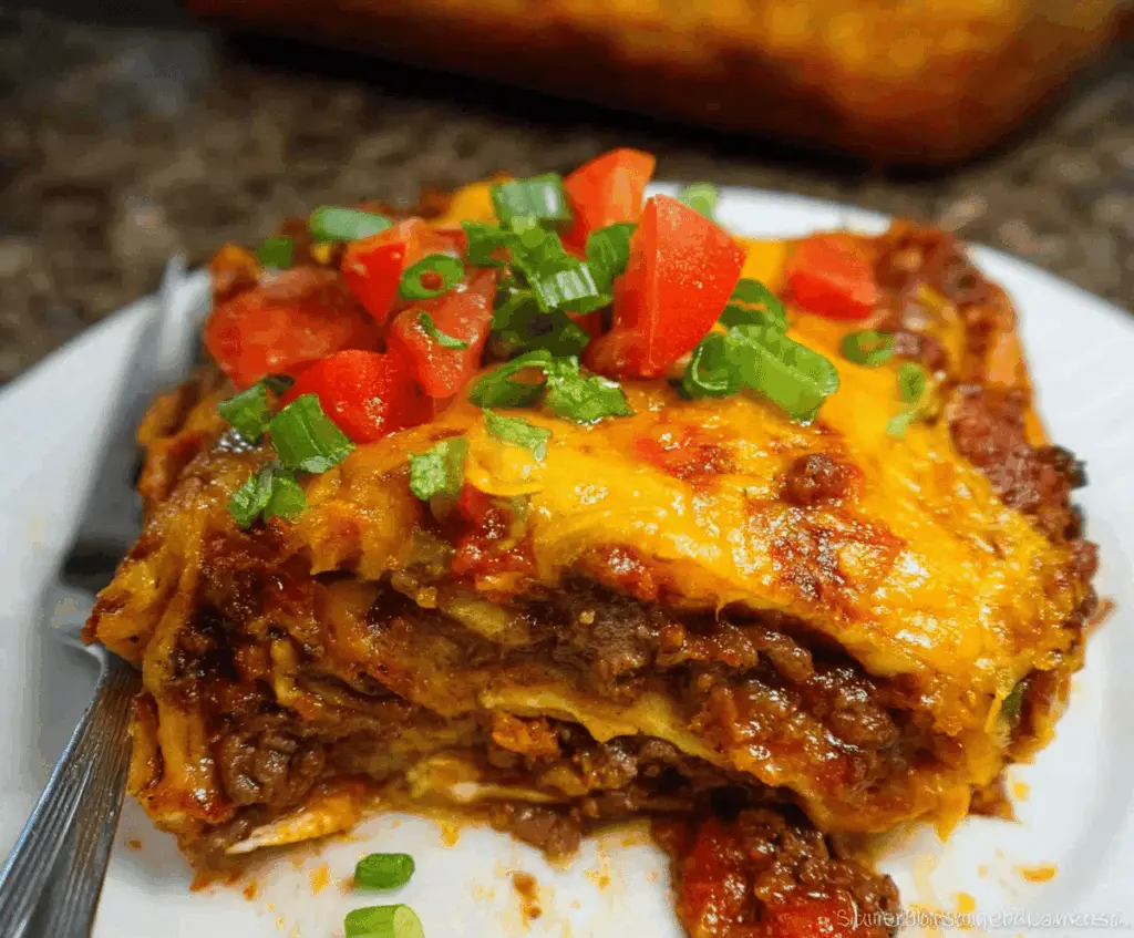 Delicious Beef Enchilada Casserole topped with melted cheese, fresh cilantro, and sliced jalapenos, served in a baking dish