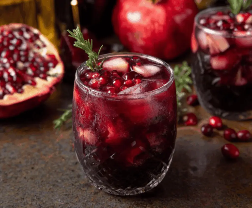 Vampire Red Sangria with fresh cranberries, pomegranate seeds, and citrus slices in a glass pitcher for a festive drink