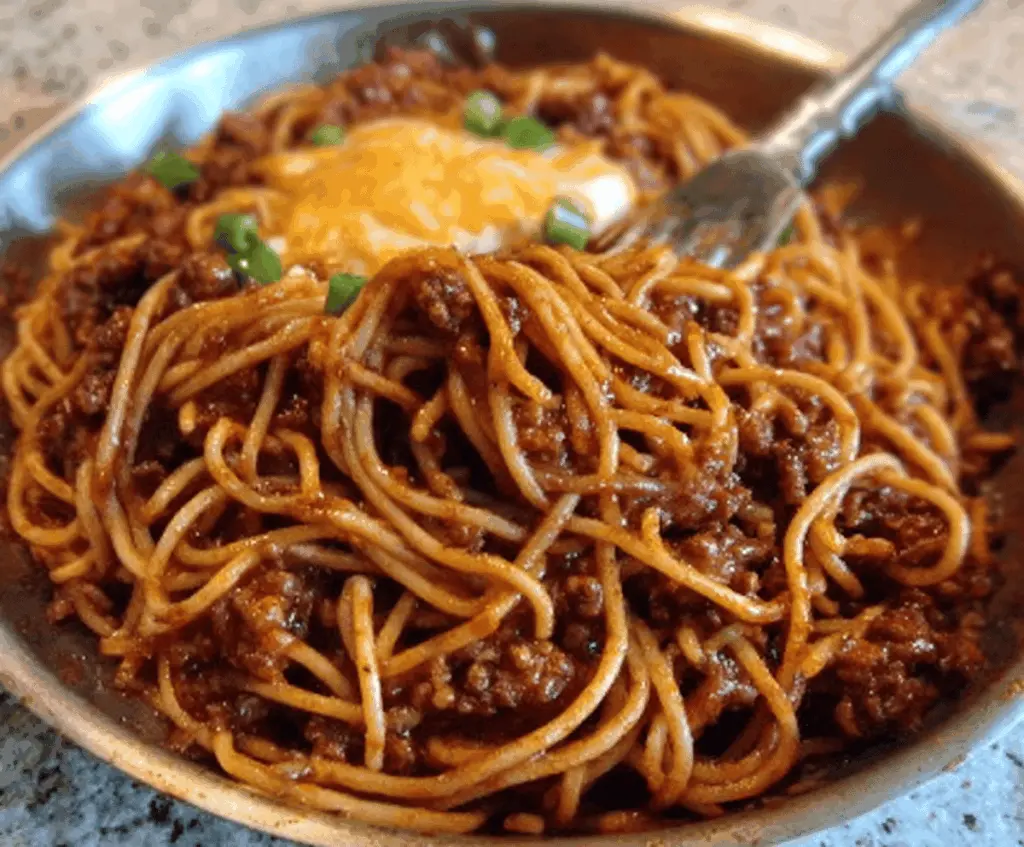 Delicious chili spaghetti dish with flavorful sauce and melted cheese on top.