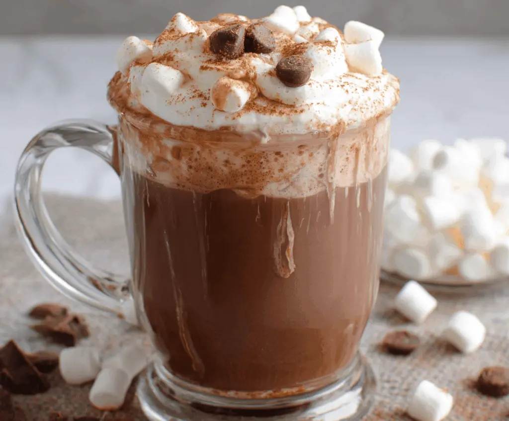 Creamy Crockpot Hot Chocolate topped with whipped cream and chocolate shavings, perfect for winter cozy nights.