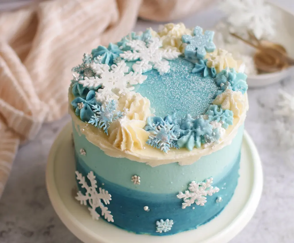 Delicious Winter Vanilla Snowflake Cake decorated with snowflake ornaments and powdered sugar, perfect for winter celebrations.