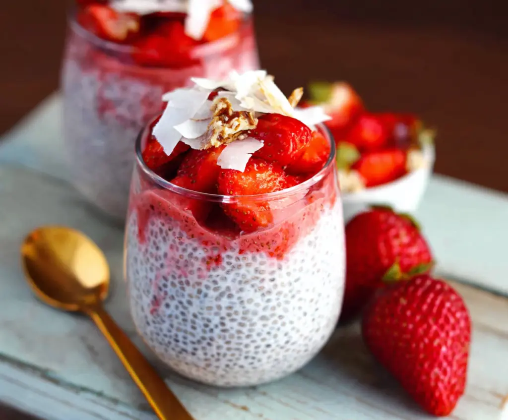 Delicious strawberry coconut chia pudding in a glass bowl garnished with fresh strawberries and shredded coconut